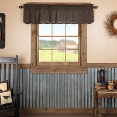 a room with a bench, table and window that has a metal curtain on it