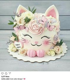 a cake decorated with flowers and a cat's face