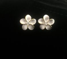 "Solid .925 Sterling Silver Hawaiian Plumeria 12MM (just under 1/2\") Stud Earrings. They have a Sandblasted Matte center with High-polished subtle 14K Gold edges and a Cubic zirconia in the Flowers center for a hint of bling. --The Plumeria is worn and often exchanged here in Hawaii as a symbol of love and friendship. --Packaged ready for gifting with a Hawaiian Plumeria story, Sterling silver cleaning instructions, a jewelry pouch and gift box." Flower-shaped Hallmarked Earrings For Anniversary, Flower Shaped Hallmarked Earrings For Anniversary, Hawaiian Plumeria, Silver Cleaning, Love And Friendship, Earrings Flower, Flower Center, Flower Studs, Love Symbols