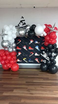 a balloon arch with black, white and red balloons