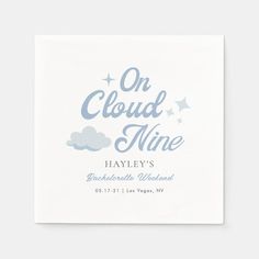 a white napkin with the words on cloud nine printed in blue and grey, against a white background