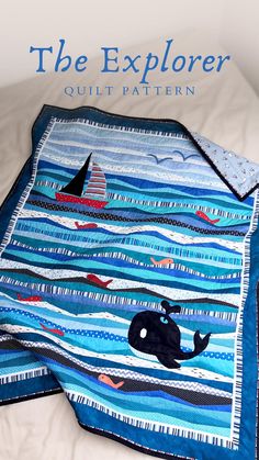 a quilted blanket on top of a bed with an image of a whale in the ocean