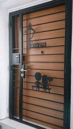 a wooden door with metal bars on the side and two people silhouettes painted on it