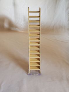 a small wooden ladder sitting on top of a white sheet