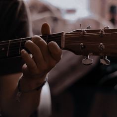 a person playing an acoustic guitar with their hands