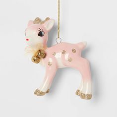 a pink and white ceramic deer ornament hanging from a gold chain