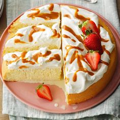 there is a cake with white frosting and strawberries on the plate