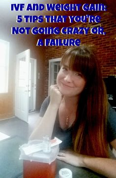 a woman sitting at a table with a drink in front of her