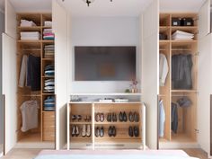 a bedroom with closets and shoes on the floor in front of a flat screen tv