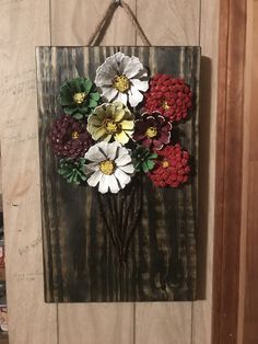 a wooden sign with flowers hanging on it