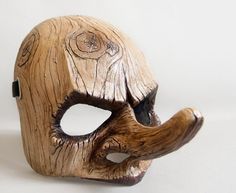 a wooden mask that has been carved to look like an elephant's head, on a white background