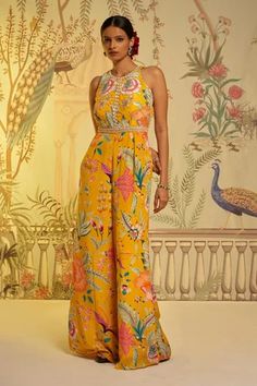 Yellow crepe silk padded jumpsuit, with floral print, halter neck and embroidered highlights on bodice. Component: 1 Pattern: Printed and Hand Embroidered Type Of Work: Floral Print, Bead and Metallic Work Neckline: Halter Neck Sleeve Type: Sleeveless Fabric: Crepe Silk Color: Yellow Other Details:  Back keyhole Back hook and eye closure Occasion: Haldi and Mehendi,Resort,Party - Aza Fashions Jumpsuit From Silk Saree, Jumpsuits For Haldi, Haldi Printed Outfit, Yellow Jumpsuit For Haldi, Traditional Jumpsuits For Women, Yellow Jumpsuit Outfit Wedding, Floral Jumpsuit Outfit Wedding, Indo Western Jumpsuits For Women, Traditional Jumpsuit