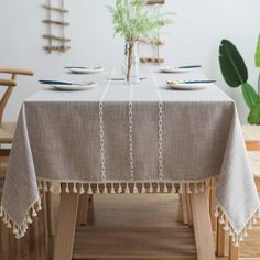 the table is set for two with plates and silverware on it, along with a potted plant