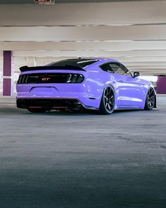 a purple mustang parked in a parking garage