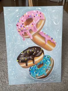 a painting of three donuts with sprinkles on them