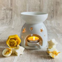 a small white vase with a lit candle in it