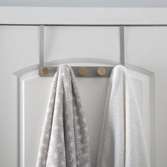 two white towels hanging on a door handle