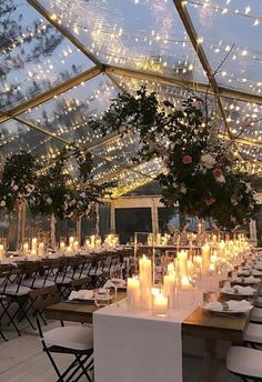 the inside of a tent with tables and chairs set up for an outdoor wedding reception