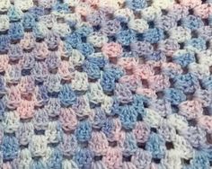 a crocheted blanket is shown in blue, pink and white