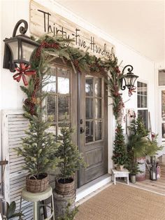 the front door of a house decorated for christmas with evergreens and pine cones on it