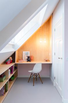 an attic bedroom with a desk and bookshelf