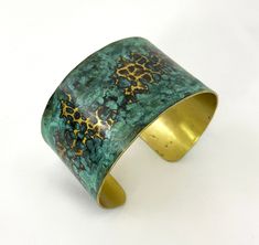 These unique, hand-formed copper and brass cuff bracelets with vibrant patinas create stunning accents to your personal style. Dress up or down- either way you'll be wearing an adornment that will turn heads, start conversations, and delight the eye of the beholder. Hammered Brass cuff with bright brass peeking through a lovely marbled green/blue patina. Please note that patina colors will look different depending on the screen/device you view them on. This is a medium cuff- see measurements bel Bronze Metal Bracelet With Patina, Adjustable Patina Bangle As Gift, Artisan Bronze Bracelets With Patina, Copper Cuff Bracelet With Patina As Gift, Artisan Bronze Patina Bracelets, Bronze Bangle Bracelet With Patina, Artistic Adjustable Patina Cuff Bracelet, Unique Patina Bangle As Gift, Patina Brass Bangle Bracelet