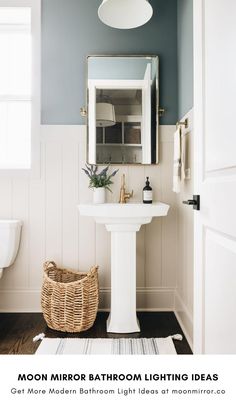 a bathroom with blue walls and white fixtures is featured in the article moon mirror lighting ideas