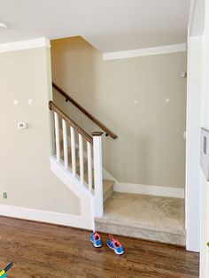 a pair of slippers sitting on the floor in front of a stair case next to an open door