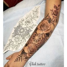 a woman's arm with flowers and leaves on it