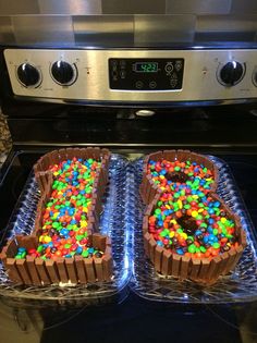 two cakes with chocolate frosting and sprinkles are on display in front of an oven