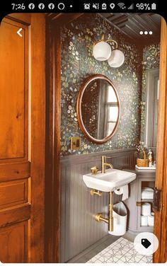 a bathroom with a sink, mirror and toilet paper dispenser in it