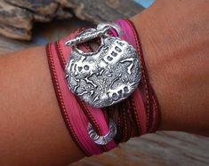 a close up of a person's arm wearing a bracelet with an elephant on it