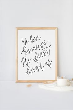 a framed print with the words we love because he isn't loved us on it