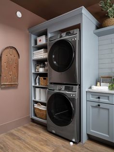 a washer and dryer in a small room with wood flooring on the walls