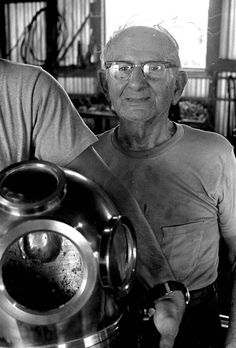 two men standing next to each other in front of a pot