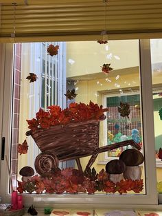 the window is decorated with fall leaves and a wheelbarrow