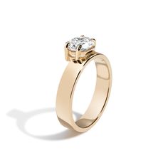 a yellow gold engagement ring with a single diamond in the center, on a white background