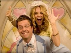 a man and woman posing in front of a stained glass window with their hands up