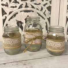 three mason jars with lace and twine on them