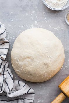 a ball of bread sitting on top of a counter next to a wooden spatula