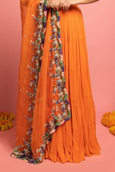 Orange embroidered lehenga in coin tassels and fringe detail. Paired with a tiered lehenga and scallop dupatta.
Components:3
Pattern:Embroidered
Type of Work:Coin tassels, Thread work
Neckline:V neck
Sleeve Length:Sleeveless
Fabric:Raw silk, Georgette, Organza
Color:Orange
Other Details:
Fringe dupatta
Note: Peach lehenga set worn by the other model is not for sale
Note: Please get in touch with our customer care service to customize the colour
Occasion:Reception,Sangeet - Aza Fashions Bohemian Dola Silk Choli For Wedding, Bohemian Dola Silk Lehenga For Weddings, Orange Embroidered Sharara With Traditional Drape, Unstitched Bohemian Lehenga In Georgette, Orange Embroidered Sharara For Navratri, Semi-stitched Bohemian Sharara In Georgette, Bohemian Georgette Sharara For Navratri, Semi-stitched Bohemian Georgette Sharara, Embroidered Orange Sharara For Navratri