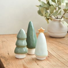 three ceramic trees sitting on top of a wooden table