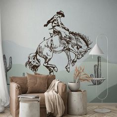 a living room with a couch, chair and wall decal that has a drawing of a cowboy riding a horse