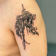 an elephant tattoo on the back of a man's shoulder