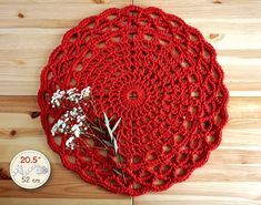 a crocheted doily with small white flowers on it and a coin sitting next to it