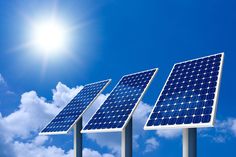 three solar panels in front of a blue sky with clouds and the sun shining on them