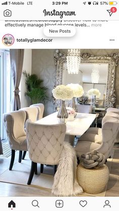 a dining room table with chairs and flowers in vases on the top of it