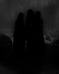 three people standing in the dark with their backs to each other