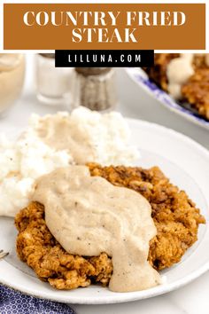 a white plate topped with fried chicken covered in gravy and mashed potatoes