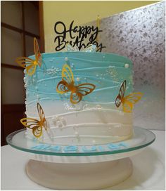 a birthday cake with butterflies on it sitting on a table